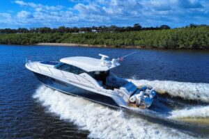 2016 Tiara Yachts C44 Coupe hardtop salon with curved windows, cream upholstery, and forward galley visible through cabin ...
