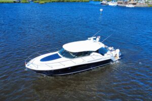 Tiara Yachts C44 Coupe cabin interior with curved settee seating, overhead lighting, and forward cabin access.