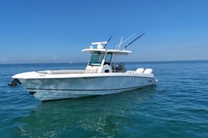 2017 Boston Whaler 330 Outrage center console fishing boat with twin outboard engines and hardtop, photographed from starb...
