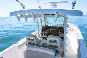 Boston Whaler 330 Outrage center console helm with dual Garmin displays, steering wheel, and forward visibility over bow.