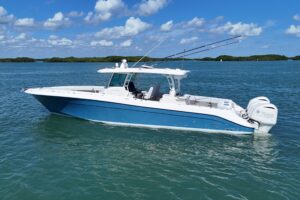 HCB 42 Siesta center console helm with dual Garmin displays, steering wheel, and forward visibility toward bow seating area.