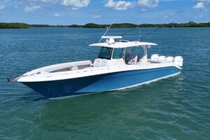HCB 42 Siesta center console helm station with dual Garmin displays and stainless steel steering wheel.