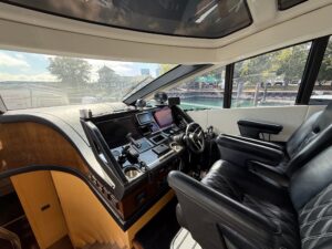 Sunseeker Predator 68 helm station with dual Garmin displays, leather helm seating, and forward visibility through windscr...