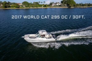 2017 World Cat 295 DC dual console catamaran with twin outboard engines shown in profile from starboard side.