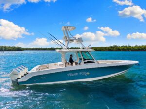 Boston Whaler 380 Outrage center console helm with dual Garmin displays, steering wheel, and forward visibility over bow.