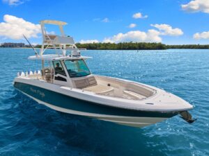 Boston Whaler 380 Outrage center console helm with dual Garmin displays, steering wheel, and forward windshield view towar...