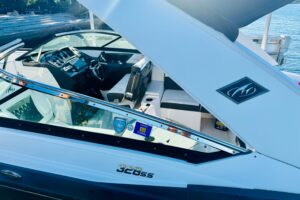 Monterey 328SS Super Sport center console helm station with dual Garmin displays, steering wheel, and throttle controls ov...