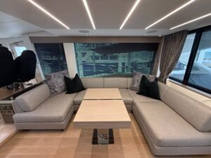 Sunseeker 74 Sport Yacht helm station with dual Garmin displays, leather helm chair, and forward cabin visibility through ...