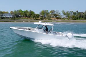 2021 Sportsman Open 322 center console boat with gray hull and white hardtop, photographed from starboard profile showing ...