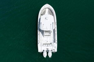 Helm station of 2021 Sportsman Open 322 center console with dual Garmin displays, steering wheel, and throttle controls.