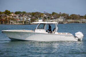 Sportsman Open 322 center console helm station with dual Garmin displays, steering wheel, and throttle controls.