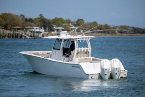 Helm station of 2021 Sportsman Open 322 center console with dual Garmin displays, steering wheel, and throttle controls.