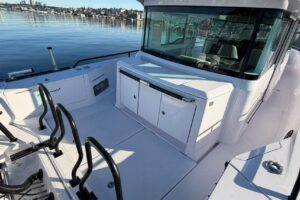 Axopar 37 XC Cross Cabin helm station with dual Garmin displays, steering wheel, and forward visibility through windscreen.