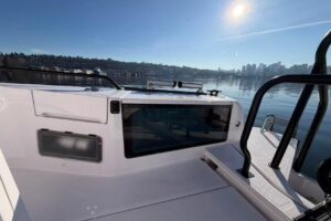 Axopar 37 XC Cross Cabin helm station with dual Garmin displays, helm seating, and forward visibility through windscreen.