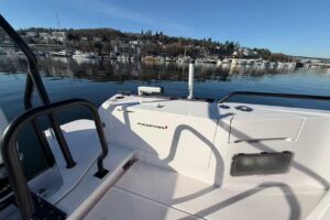 Axopar 37 XC Cross Cabin helm station with dual Garmin displays, center console steering, and forward visibility through w...