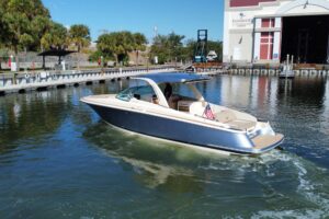 Chris-Craft Launch 35 GT center console helm with dual Garmin displays, steering wheel, and throttle controls overlooking ...