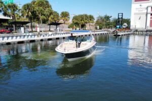 Chris-Craft Launch 35 GT helm station with dual Garmin displays, leather helm seat, and forward windshield view of cabin c...