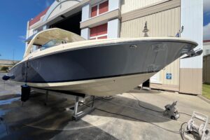 2022 Chris-Craft Launch 35 GT center console helm with dual Garmin displays, steering wheel, and throttle controls overloo...