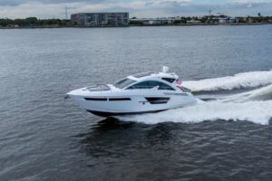 Bow seating and foredeck of 2022 Cruisers Yachts 54 Cantius with cushioned lounge area and windscreen.