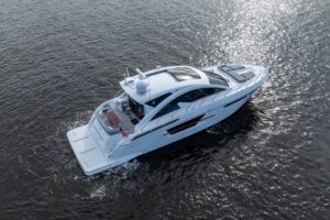 2022 Cruisers Yachts 54 Cantius salon with neutral upholstery, large windows, and ambient cabin lighting.