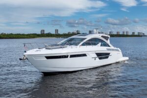 2022 Cruisers Yachts 54 Cantius salon with neutral upholstered seating, entertainment center, and ambient cabin lighting.