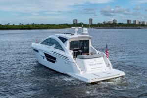 2022 Cruisers Yachts 54 Cantius salon with neutral upholstery, curved seating, entertainment center, and natural cabin lig...