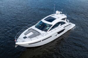 2022 Cruisers Yachts 54 Cantius salon with curved seating, entertainment center, and natural light from cabin windows.