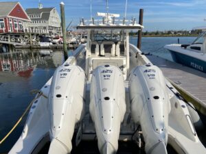 Pursuit S 378 Sport center console helm with dual Garmin displays, steering wheel, and helm seating in cockpit.