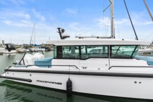 Axopar 37 XC Cross Cabin helm station with dual Garmin displays, helm seating, and forward cabin visibility through windsc...