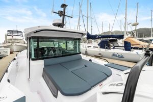Axopar 37 XC Cross Cabin helm station with dual Garmin displays, helm seating, and forward visibility through windscreen.