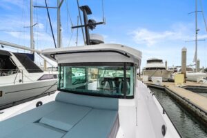 Axopar 37 XC Cross Cabin helm station with dual Garmin displays, leather helm seat, and forward visibility through windscr...