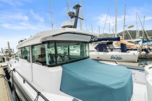 Axopar 37 XC Cross Cabin helm station with dual helm seats, center console steering, and forward windscreen visibility.