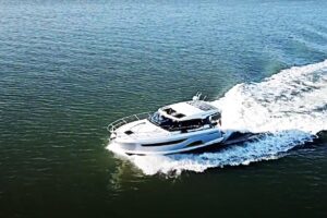 2023 Bavaria R40 Coupe helm station with dual Garmin displays, leather helm seating, and hardtop overhead in the pilothouse.