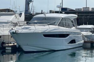 2023 Bavaria R40 Coupe helm station with dual Garmin displays, leather helm seat, and forward cabin visibility through win...