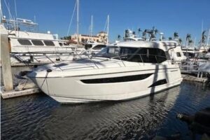 2023 Bavaria R40 Coupe helm station with dual Garmin displays, leather helm seating, and hardtop overhead in the pilothouse.
