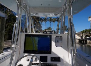 Contender 32 ST center console helm station with dual Garmin displays, steering wheel, and throttle controls.