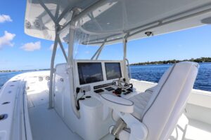 Contender 44 ST center console helm station with dual Garmin displays, steering wheel, and throttle controls overlooking t...