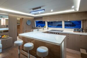 Bow seating and forward cabin entry on 2023 Horizon PC60 motor yacht with teak decking and stainless steel railings.