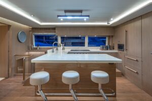 2023 Horizon PC60 pilothouse yacht helm station with dual Garmin displays, leather helm chair, and forward visibility thro...