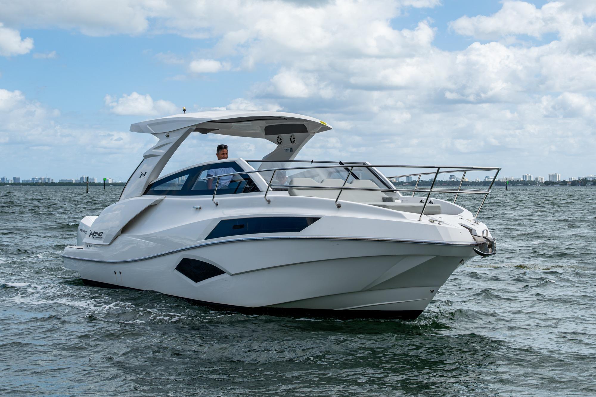 2023 NX Boats NX 340 center console profile showing 32-foot hull with hardtop, helm station, and outboard engines in Miami.