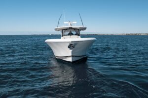Pursuit S 428 Sport center console helm station with dual Garmin displays, leather helm seat, and hardtop overhead.