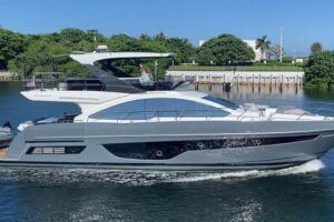 2023 Schaefer 660 salon with cream upholstered seating, teak flooring, and large windows overlooking the water.