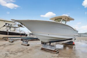 Scout 305 LXF center console helm station with dual Garmin displays, steering wheel, and throttle controls overlooking the...