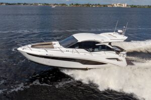 Galeon 425 HTS helm station with dual Garmin displays, leather helm seat, and forward visibility through hardtop-protected...
