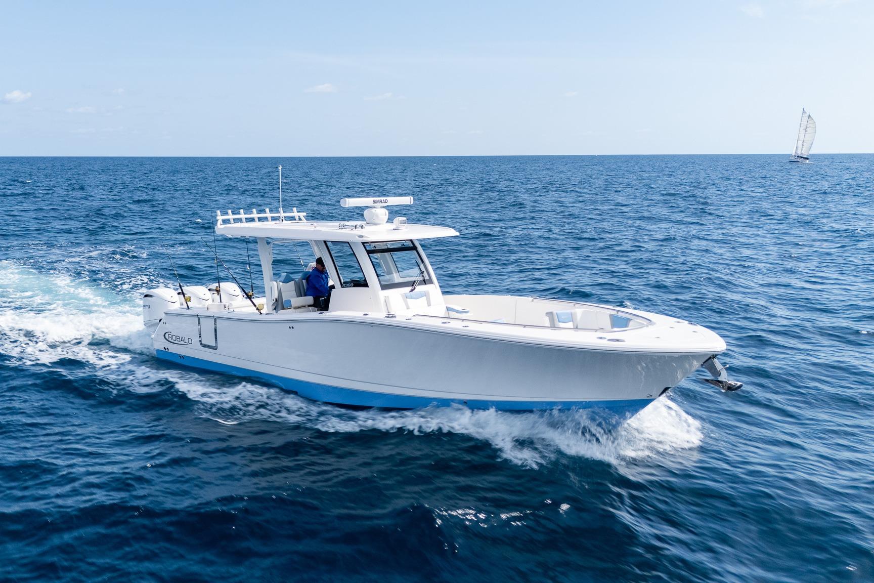 2024 Robalo R360 center console with triple outboard engines shown in starboard profile view at dock in North Miami, Florida.