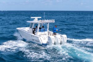Robalo R360 center console helm station with dual Garmin displays, steering wheel, and throttle controls overlooking the bow.