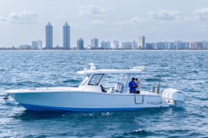 2024 Robalo R360 center console helm station with dual Garmin displays, steering wheel, and throttle controls overlooking ...