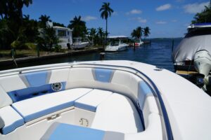 Robalo R360 center console helm station with dual Garmin displays, black helm seat, and stainless steel steering wheel.