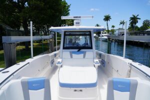 2024 Robalo R360 center console helm station with dual Garmin displays, steering wheel, and throttle controls overlooking ...