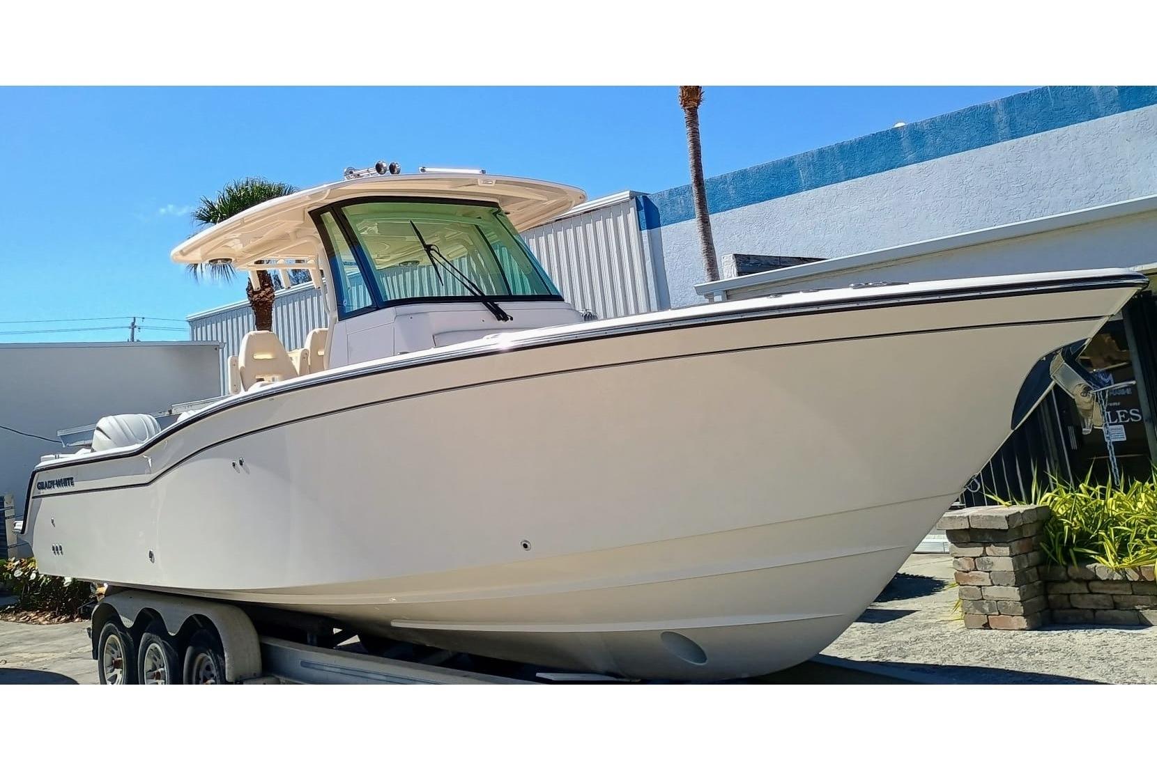 2025 Grady-White Canyon 326 center console fishing boat with hardtop and outboard engines moored in Riviera Beach, Florida.
